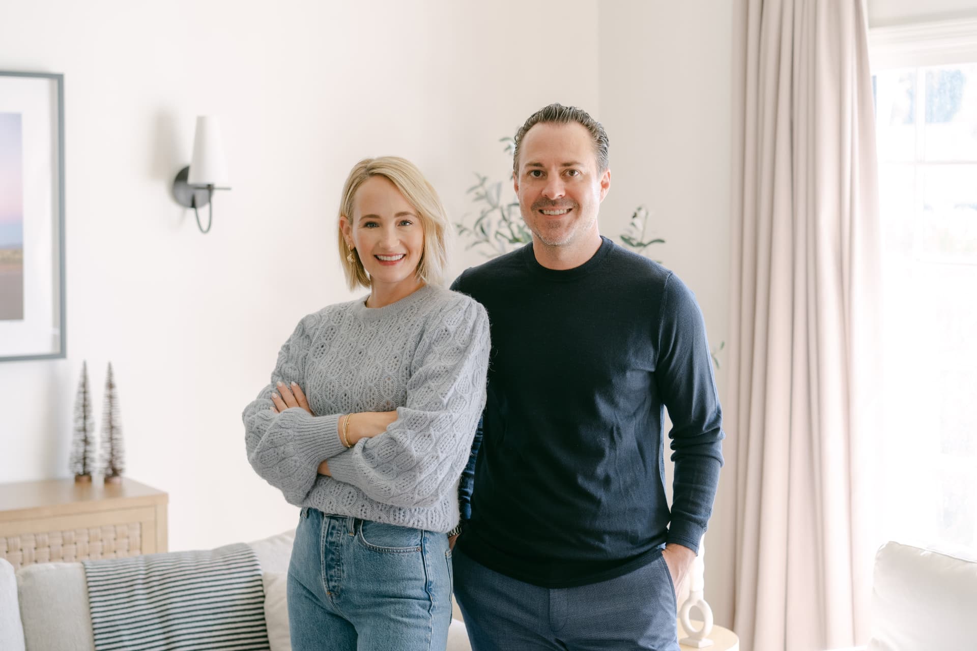 Ashley and Doug of DMF Realty standing in a bright Los Angeles living room
